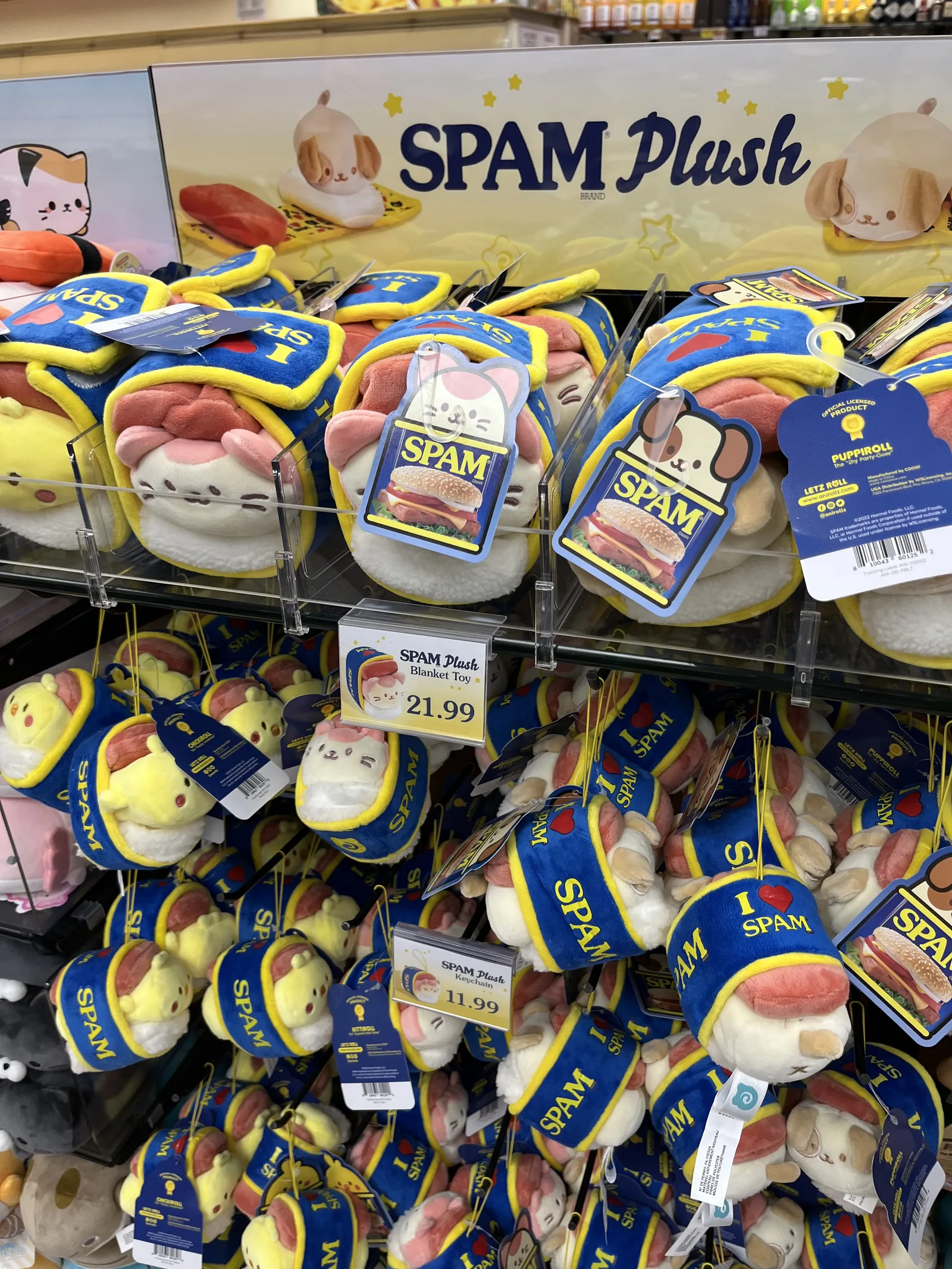 スパムの缶を布団のようにかぶった動物のぬいぐるみが棚いっぱいに並んでいる