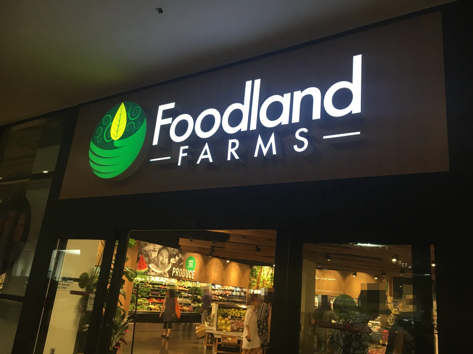 緑の葉のロゴと「Foodland FARMS」の看板が光る入口。ガラス越しに野菜や果物の売り場が見える