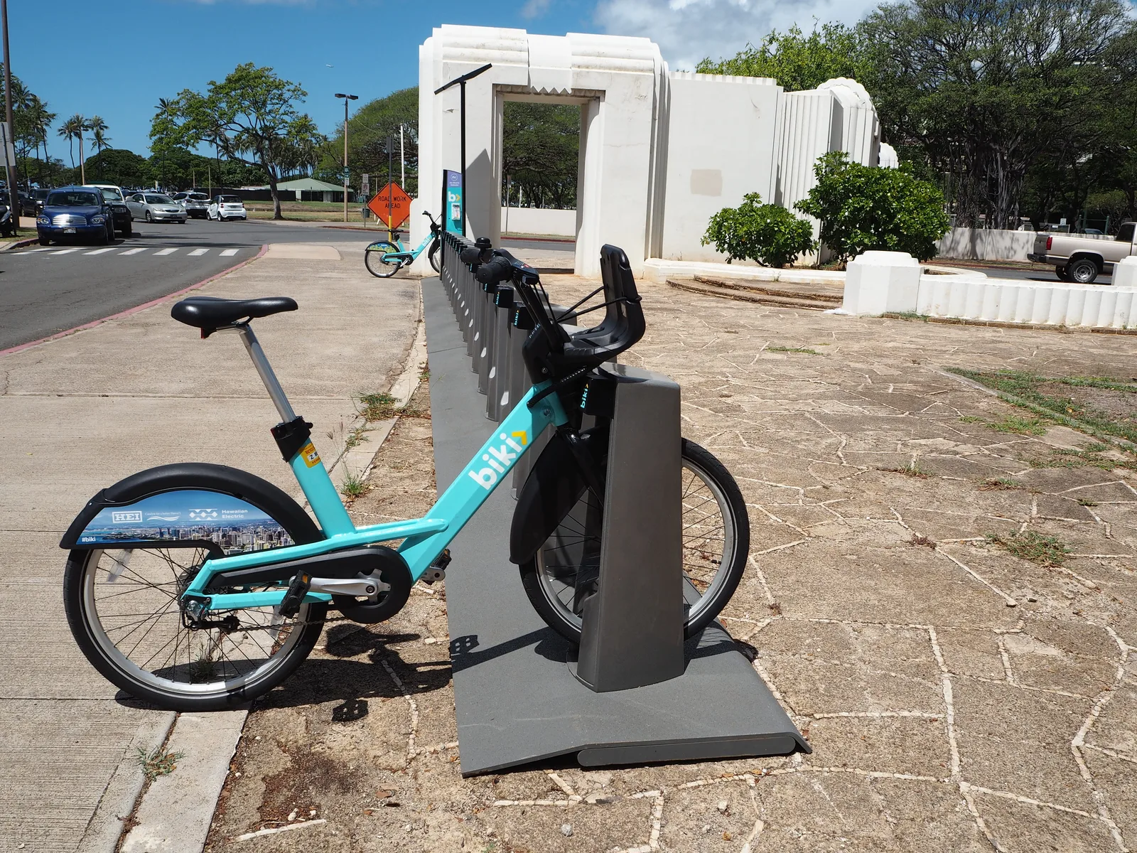 ドックの柱に差し込まれたターコイズ色のBikiの自転車と、奥に続くドックの列、白い門のような建物