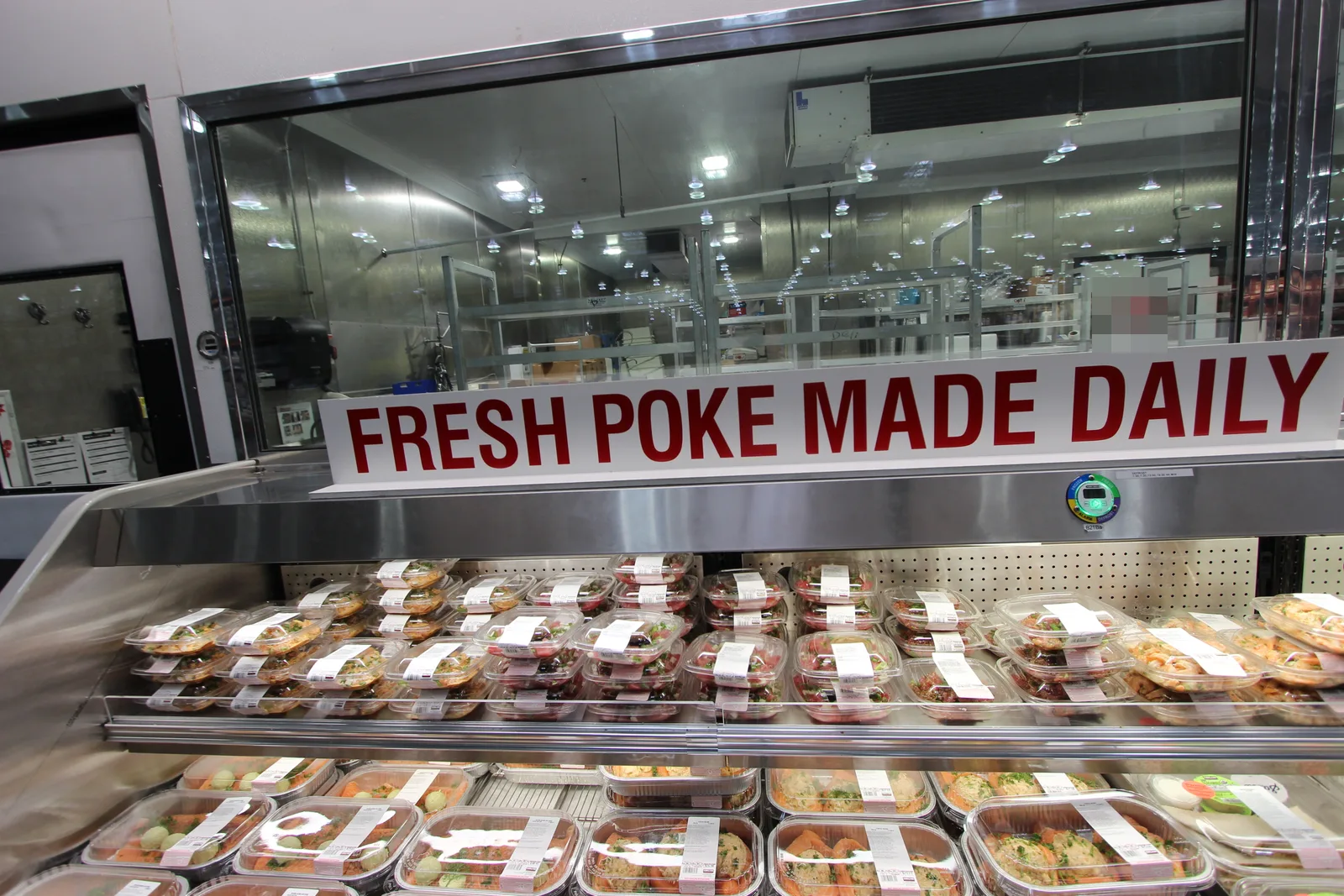 「FRESH POKE MADE DAILY」の看板の下の冷蔵ケースに、ポケやお惣菜のパックがずらりと並ぶ