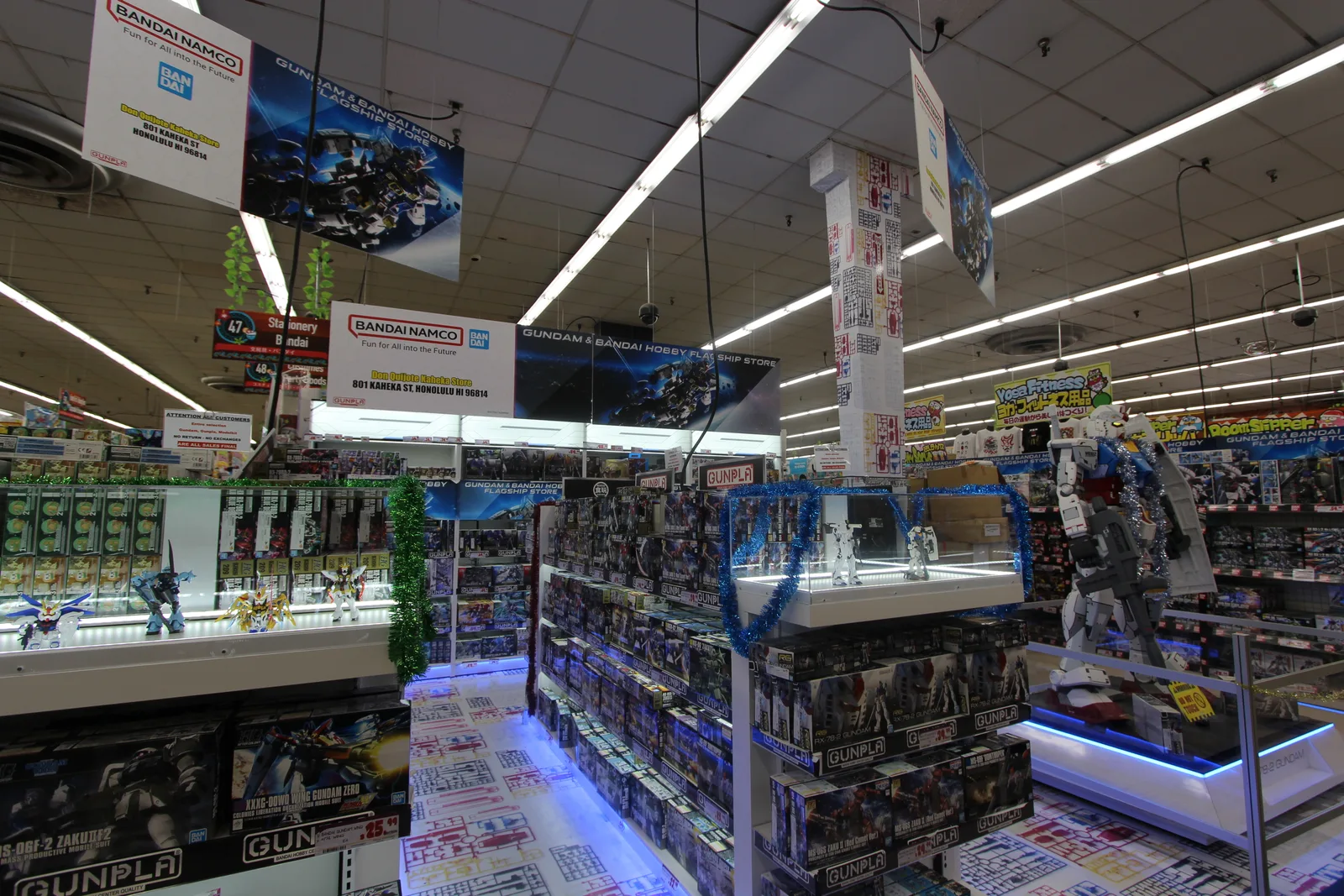 「BANDAI NAMCO」の看板の下に、ガンダムのプラモデルの箱やフィギュアが並ぶ売り場