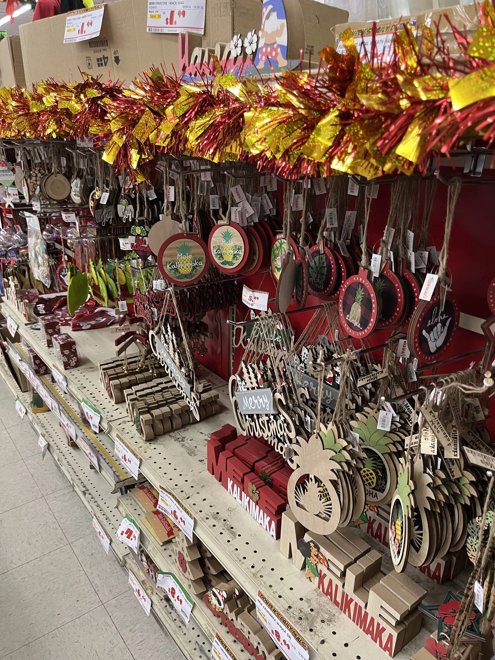パイナップルの形の木のオーナメントや「KALIKIMAKA」と書かれた飾りが棚いっぱいに並ぶ