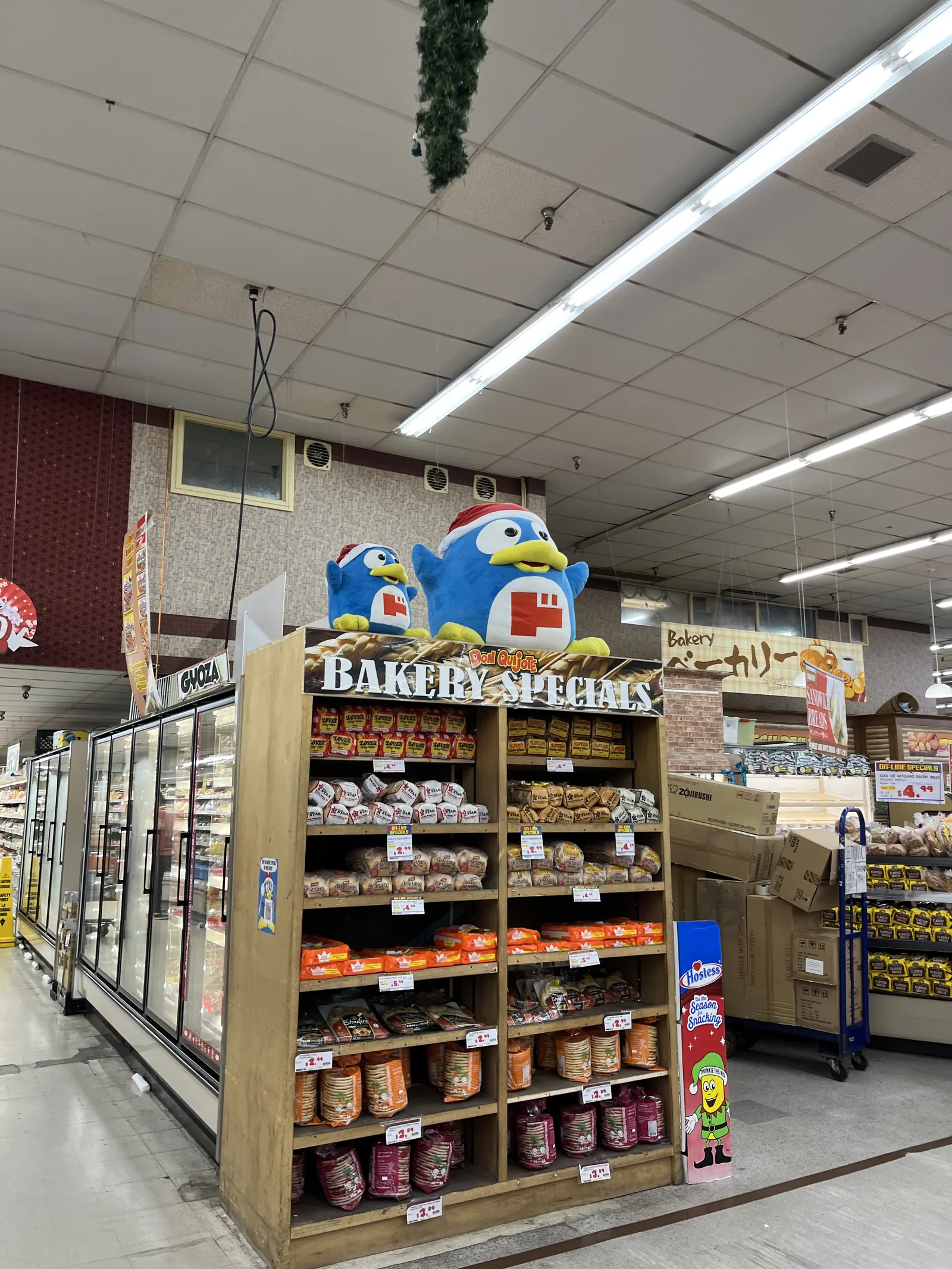 サンタ帽のドンペンのぬいぐるみが乗った「BAKERY SPECIALS」の棚に、パンやお菓子が並ぶ