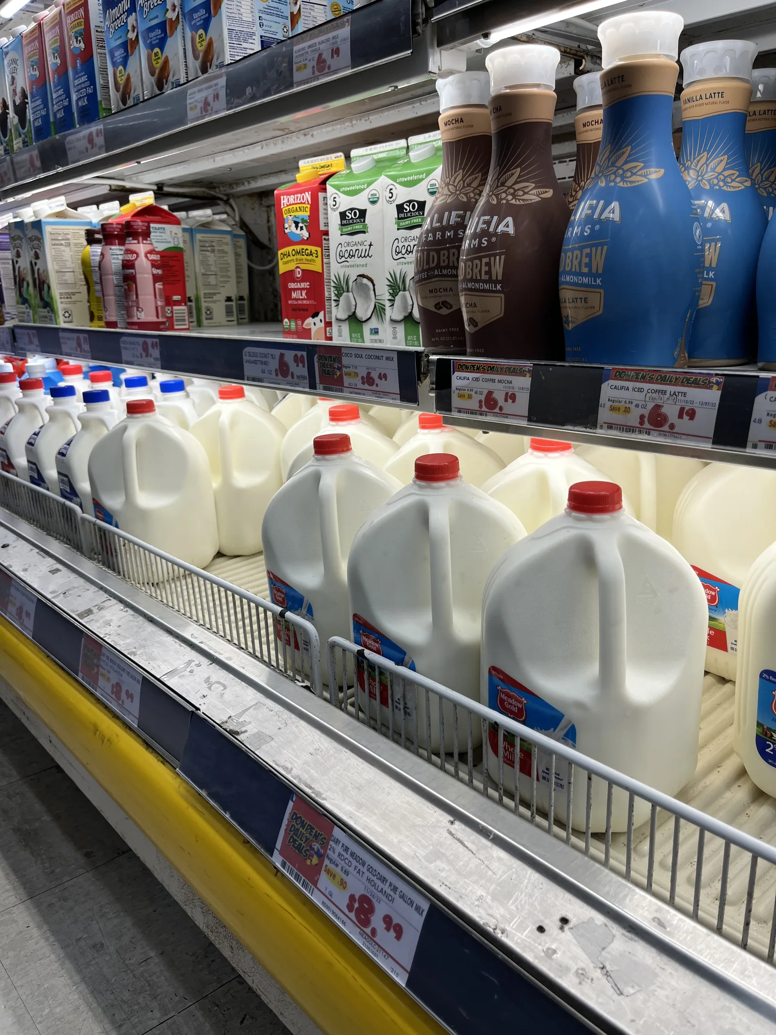 ガロンサイズの牛乳のボトルや、オーツミルク、コーヒー飲料が並ぶ冷蔵棚