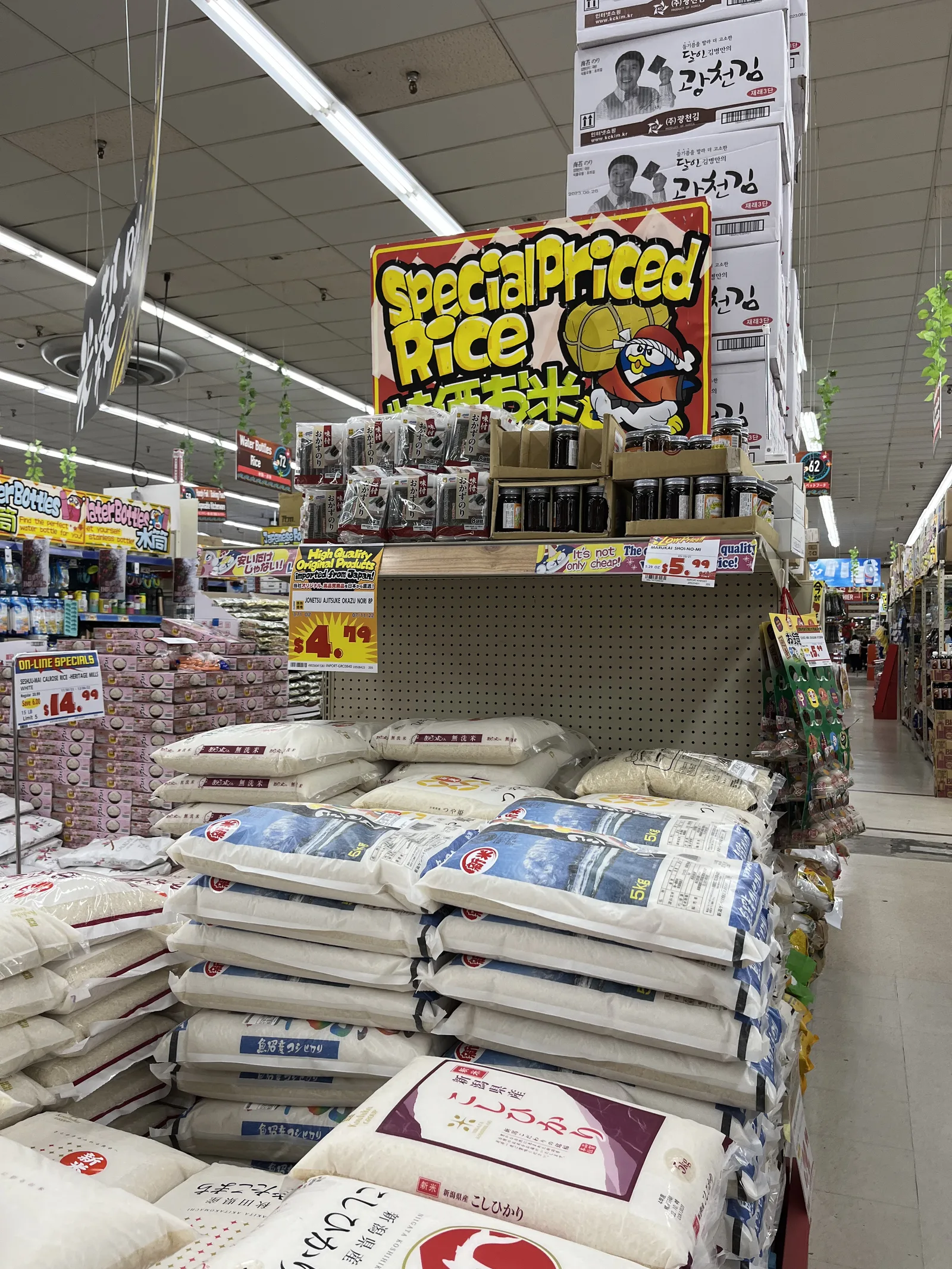 「Special Priced Rice」の看板の下に、日本のお米の袋が山積みになっている