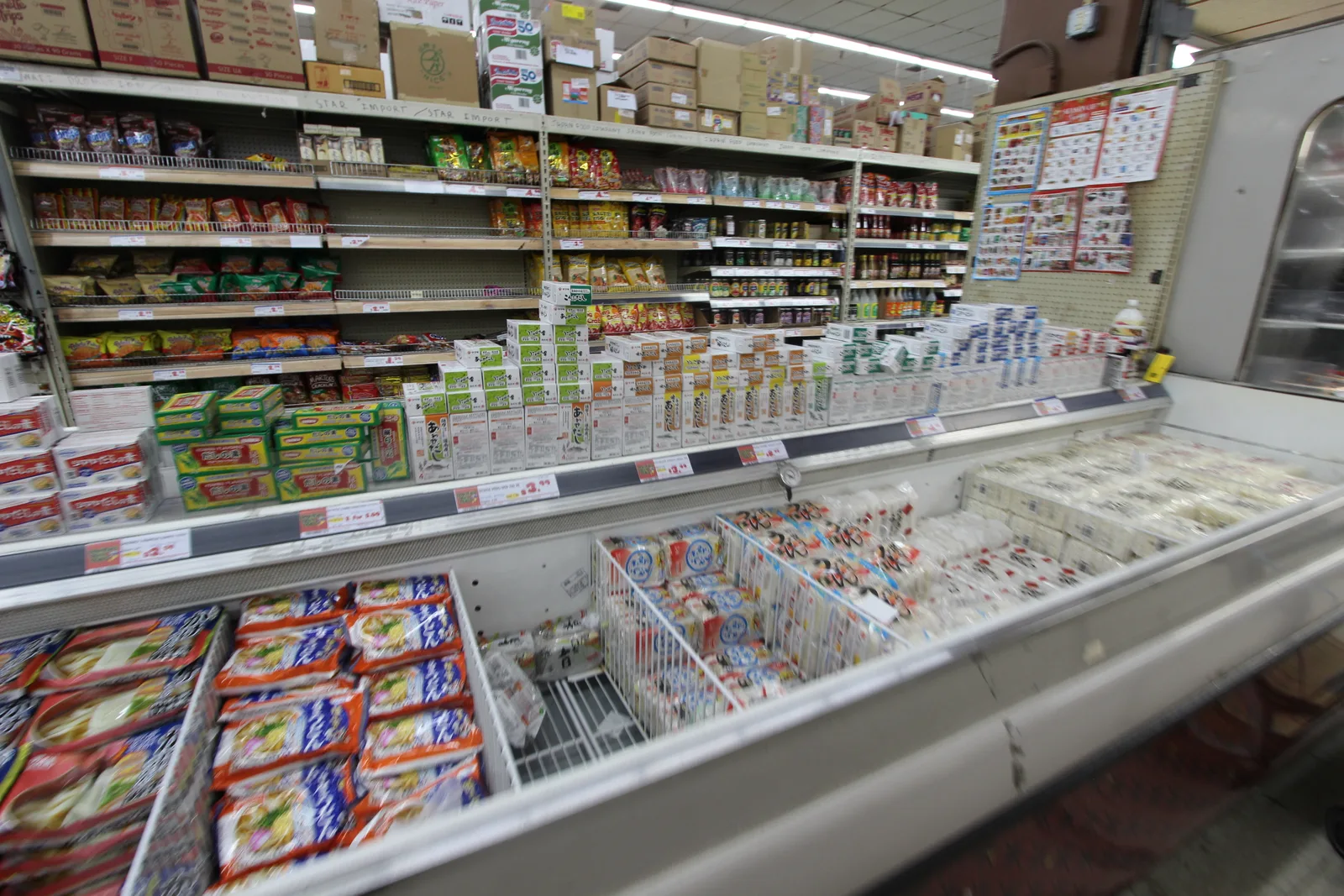 冷蔵ケースに日本の食品のパックが並び、奥の棚に日本のお菓子や食品が並ぶ