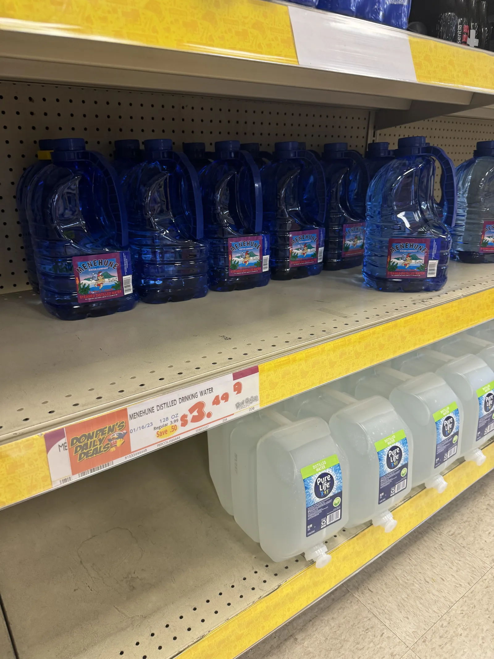 1ガロンほどの青いボトルや白いタンクの水が並び、3.49ドルの値札が付いている