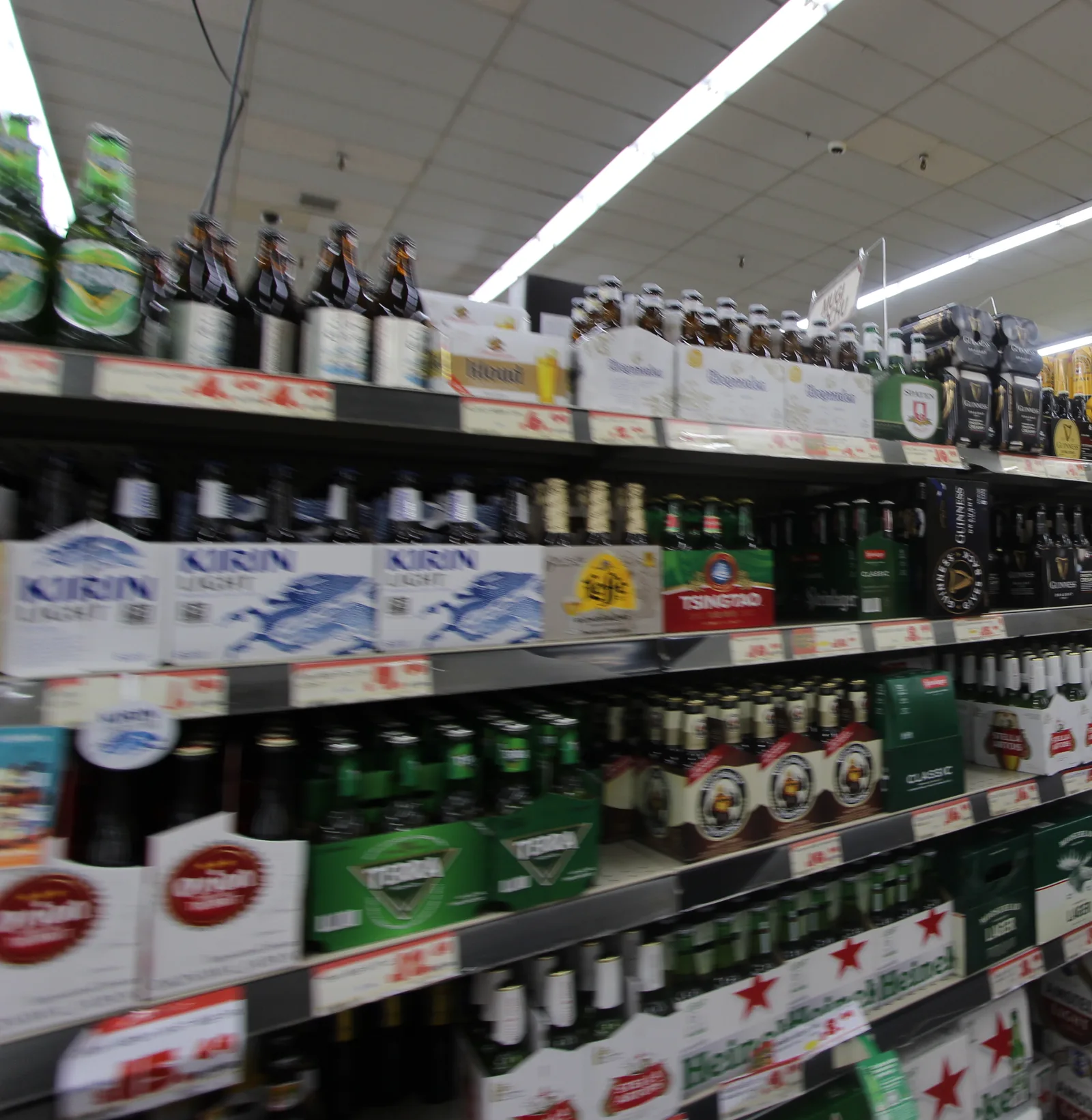 キリンやハイネケン、青島ビールなどの瓶ビールのパックが並ぶ棚