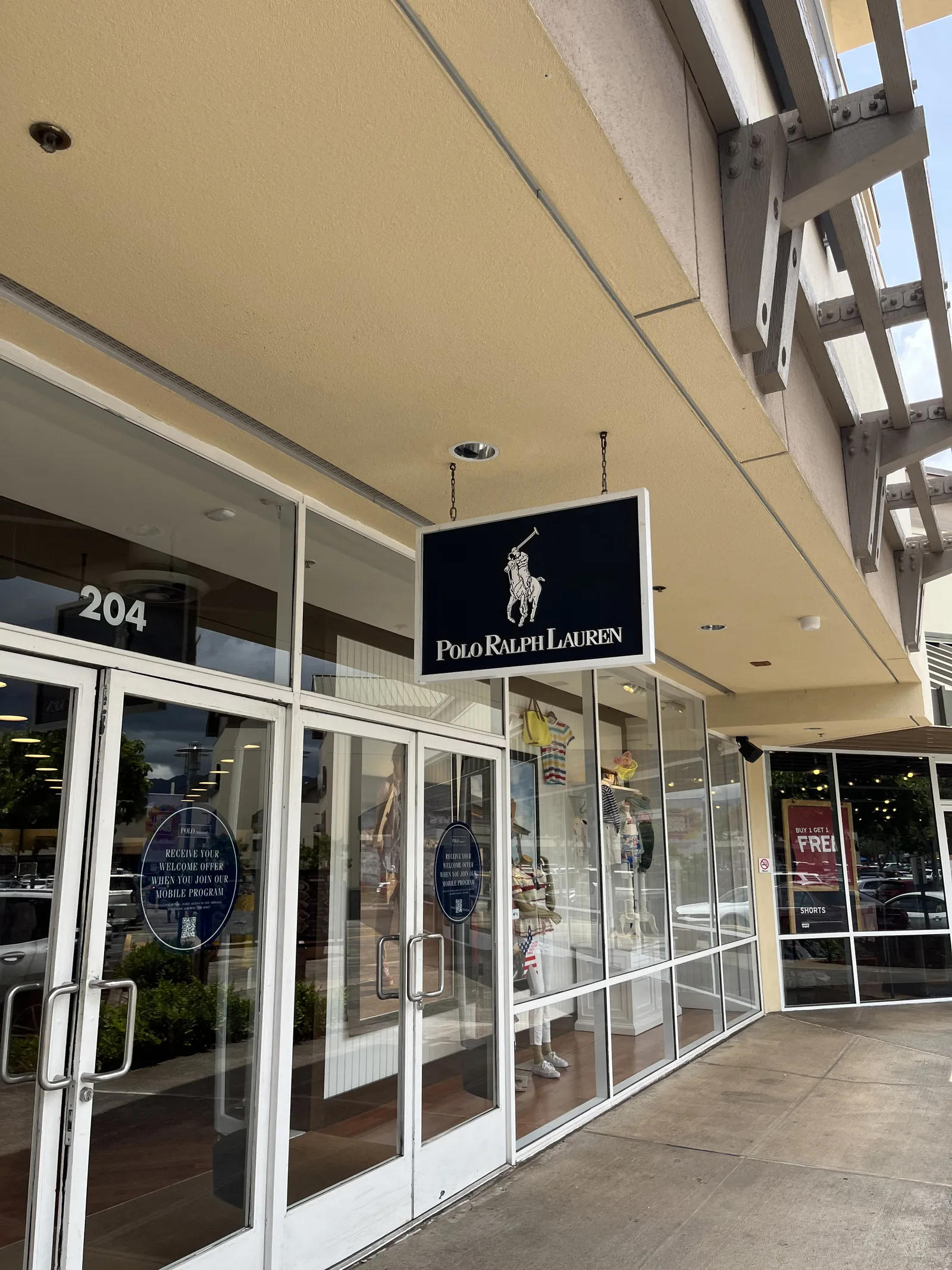「POLO RALPH LAUREN」の吊り看板と、204の番号が入ったガラス扉の店舗。ショーウインドーにマネキンが並ぶ