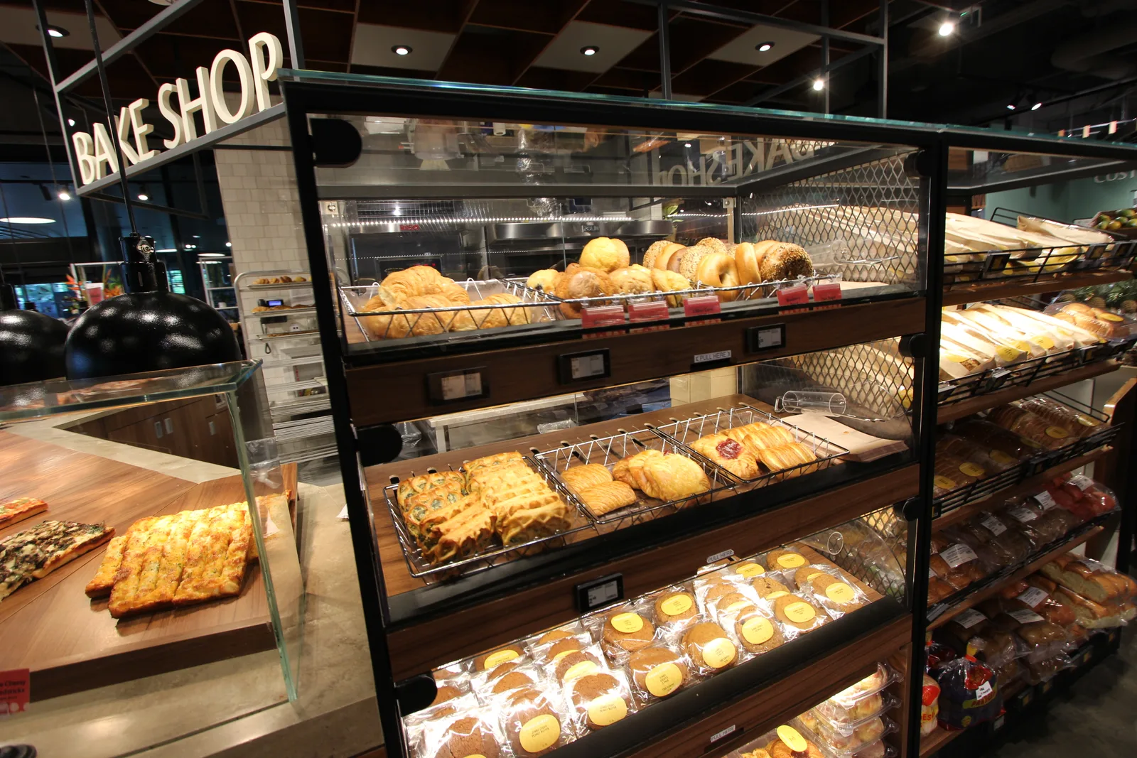 「BAKE SHOP」の看板の下のガラスケースに、クロワッサンやベーグル、焼き菓子が並ぶ