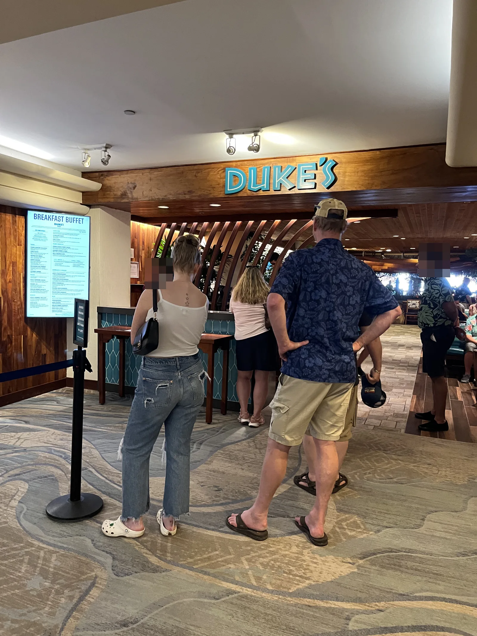 「DUKE'S」の看板の下で入口に並ぶ人たちと、左側の「BREAKFAST BUFFET」のメニュー画面