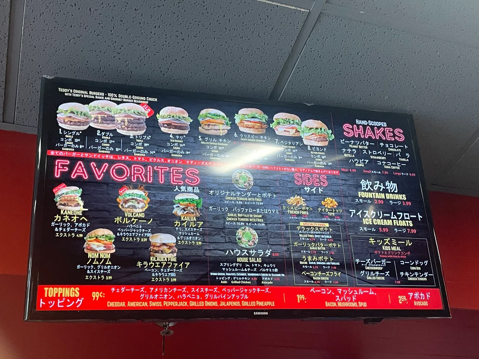 バーガーの写真が並ぶ黒いメニュー画面。英語の下に「人気商品」「サイド」「キッズミール」など日本語が書かれている