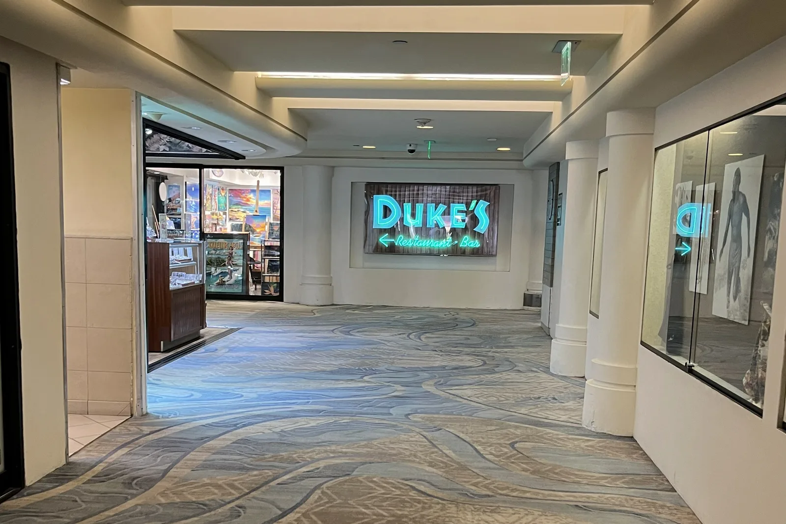 ホテルの館内の通路の突き当たりに、水色に光る「DUKE'S Restaurant・Bar」の看板