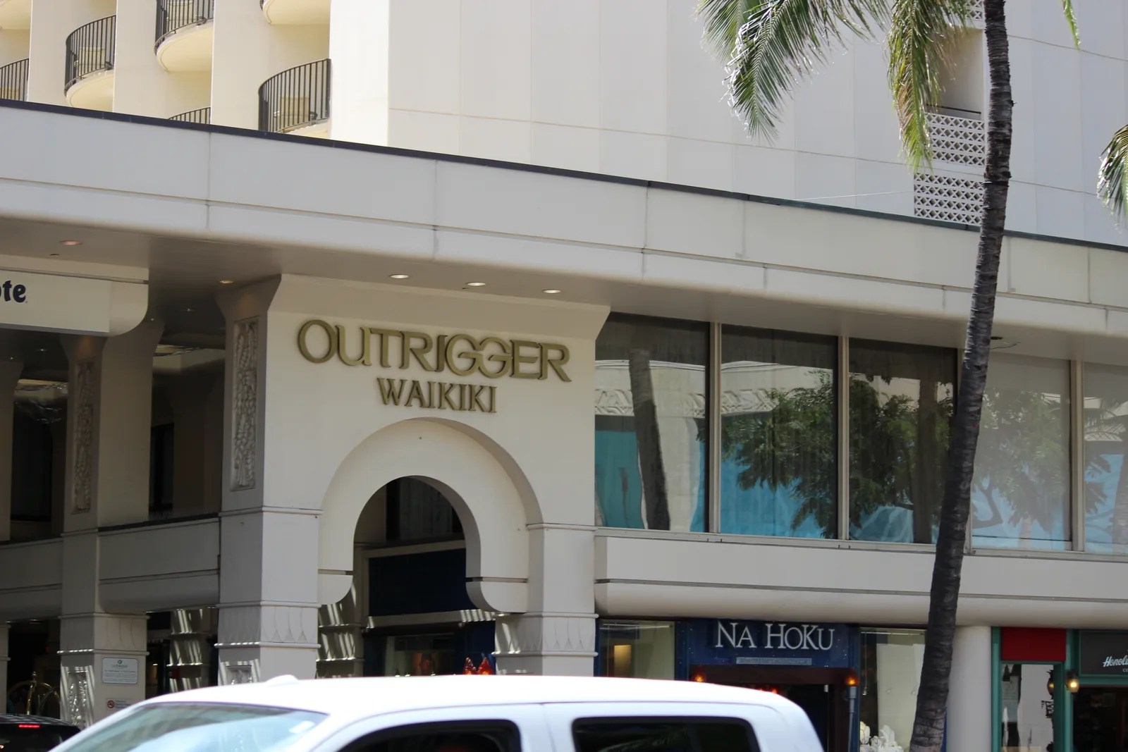 白いアーチの上にOUTRIGGER WAIKIKIの文字がある、カラカウア通り側の入り口